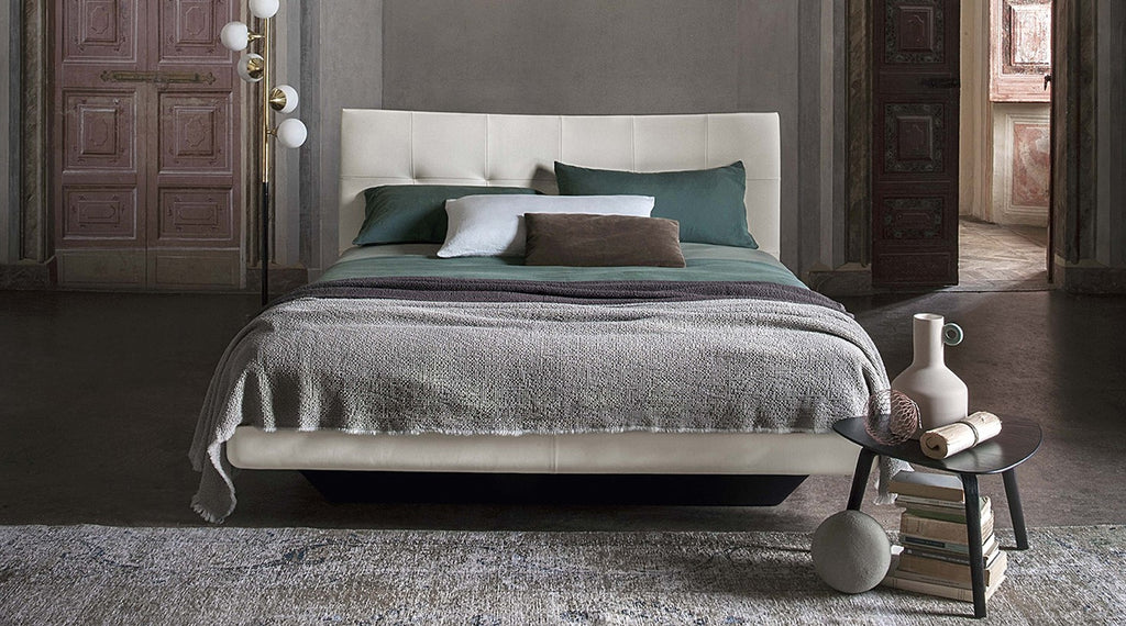 Aurora Duo bed by Poltrona Frau in Pelle Frau® leather with capitonné headboard, trapezoidal wooden base, and optional storage unit. Luxurious Italian craftsmanship. by Poltrona Frau for sale at Home Resource Modern Furniture Store Sarasota Florida