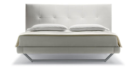 Aurora Duo bed by Poltrona Frau in Pelle Frau® leather with capitonné headboard, trapezoidal wooden base, and optional storage unit. Luxurious Italian craftsmanship. by Poltrona Frau